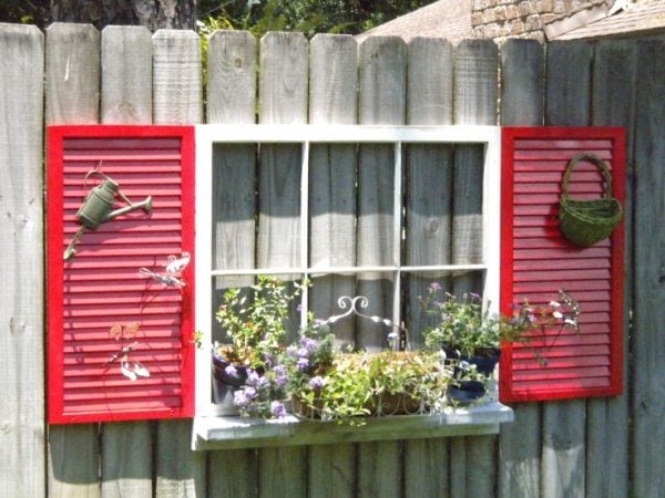 source unknown - old window with sill and shutters on fence - via Remodelaholic